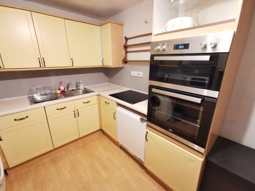 a kitchen with yellow cabinets and a stove top oven at Huge 6-Bed Apartment in Darlington Centre in Darlington