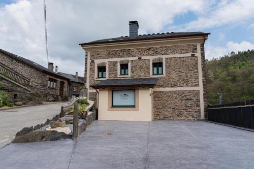 a small brick building with a window on it at Apartamentos Rurales Casa Llongo in Coaña