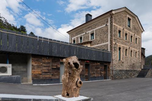 a tree stump in front of a building at Apartamentos Rurales Casa Llongo in Coaña