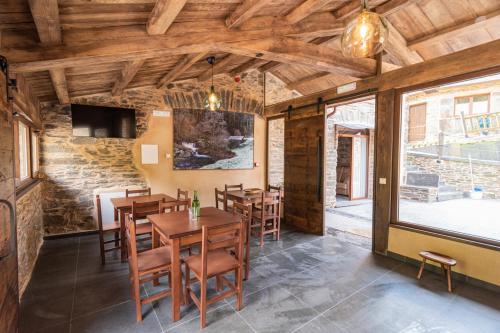 a dining room with wooden tables and chairs at Apartamentos Rurales Casa Llongo in Coaña
