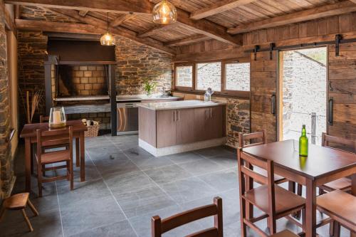 a kitchen with a sink and a table and chairs at Apartamentos Rurales Casa Llongo in Coaña