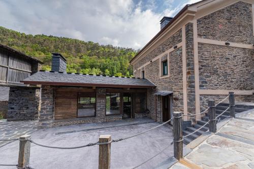 a stone building with a fence in front of it at Apartamentos Rurales Casa Llongo in Coaña