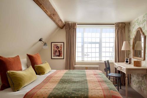 a bedroom with a bed and a desk and a window at The Falstaff in Canterbury in Canterbury