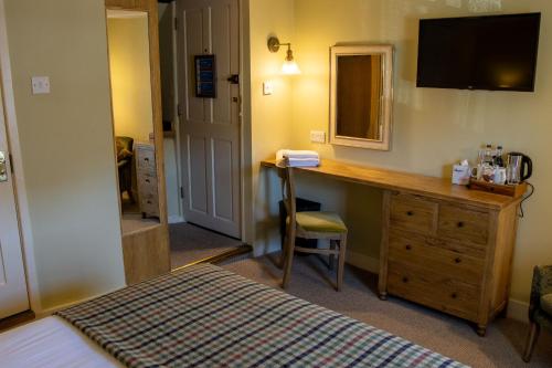 a bedroom with a desk and a bed and a mirror at The Green Dragon in Marlborough