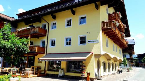 a large yellow building with balconies and a store at Haus Veronika - Appartements by Miha in Westendorf