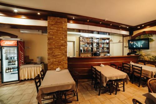 a restaurant with tables and chairs and a bar at Dvina Hotel in Velikiy Ustyug