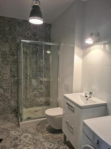a bathroom with a shower and a toilet and a sink at Apartament w Centrum IV in Ustka