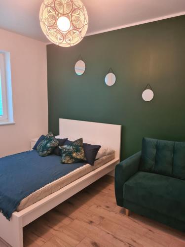 a bedroom with a bed and a green wall at Apartament w Centrum IV in Ustka