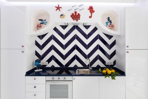 a kitchen with a black and white checkered wall at Positamy in Positano