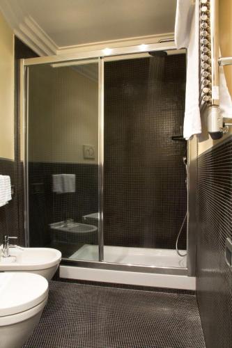 a bathroom with a shower and a toilet and a sink at Marcella Royal Hotel - Rooftop Garden in Rome