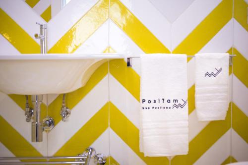 a bathroom with a sink and a yellow and white wall at Positamy in Positano
