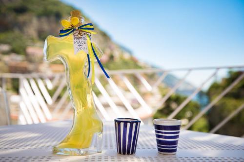 a yellow vase sitting on a table with two cups at Positamy in Positano