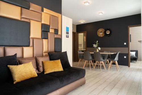een woonkamer met een zwarte bank en een tafel bij ATANA Luxury Apartments in Siófok