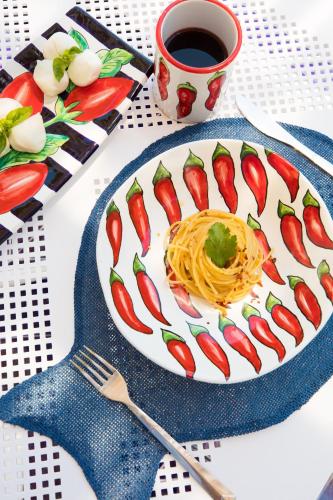 a plate of spaghetti on a table with a cup of coffee at Positamy in Positano