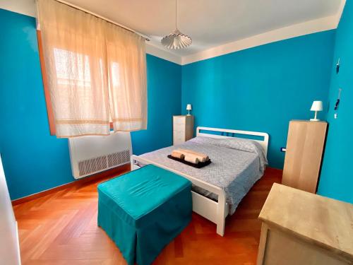 een blauwe slaapkamer met een bed en een blauwe muur bij Residenza le quattro palme in Alghero