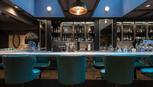 a bar with blue chairs in a restaurant at The Falstaff in Canterbury in Canterbury