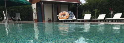 a swimming pool with chairs and a donut on the side at Meggyes Hotel in Szerencs