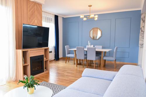 - un salon avec un canapé et une salle à manger dans l'établissement NIDEHO Estate Apartmani, à Zlatibor