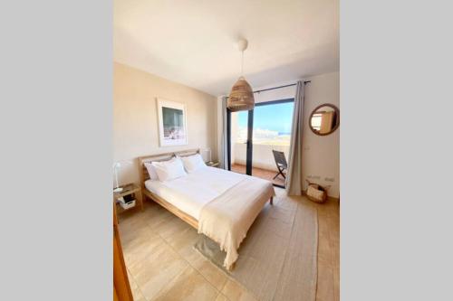 a bedroom with a bed and a view of the ocean at Wave & Chill -The House- in Cotillo