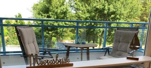 un patio con 2 sedie e un tavolo sul balcone di Duhnentraum direkt am Sandstrand, Zentrum, Balkon, Meerblick, Parkplatz, Aufzug, Wlan Netflix uvm a Cuxhaven