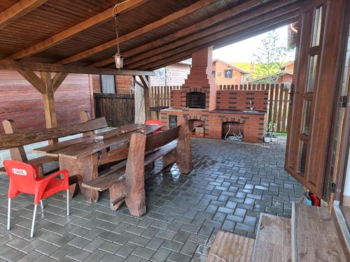 a patio with a wooden bench and a fireplace at Cabana Soral Baile Figa in Beclean