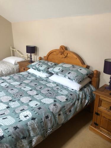 a bedroom with a bed with a blue and white quilt at Bogma Cottages in Durham