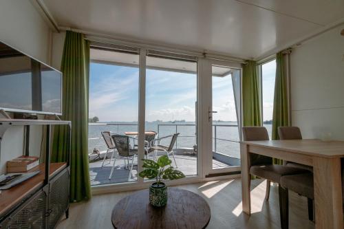 a living room with a view of the water at Blackbird in Biddinghuizen
