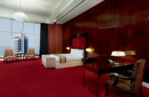 a hotel room with a bed and a desk and a desk at Best Plaza West Bay Hotel in Doha