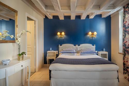 une chambre avec un mur bleu et un lit dans l'établissement Le Clos Richelieu, à Amboise