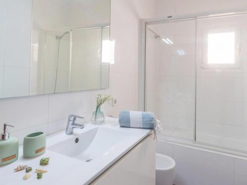 a white bathroom with a sink and a shower at Casa Antonio Sea View in Cala Santanyi