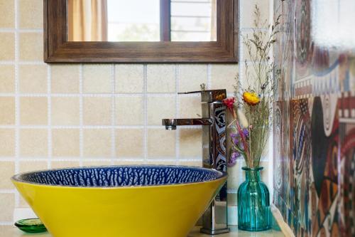 a yellow bowl sink in a bathroom with a faucet at Hangzhou Citynest Music B&B in Hangzhou