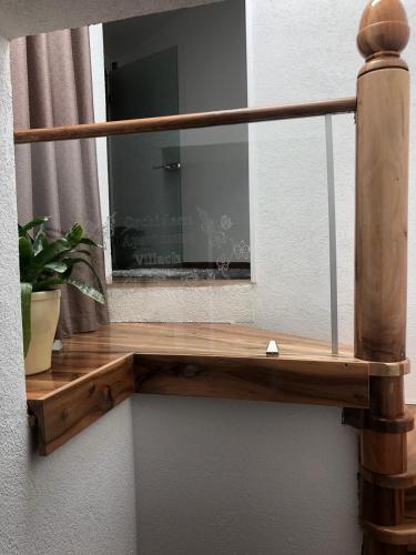 a mirror on a wall with a wooden shelf at Orchideen Apartment in Villach