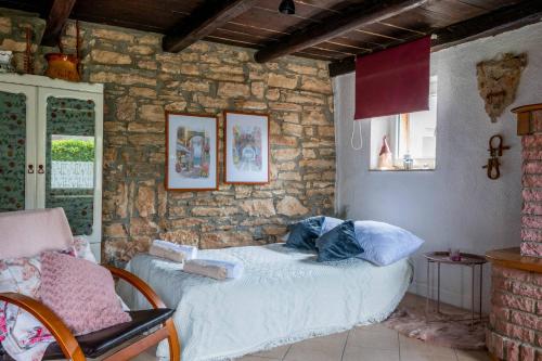 a bedroom with a bed and a stone wall at Holiday house Ruba in Marčana