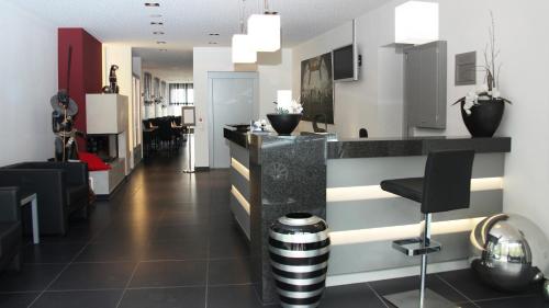 a lobby with a bar with a counter and chairs at Hotel Zur Post in Trier