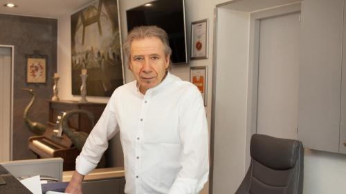 a man in a white shirt standing in an office at Hotel Zur Post in Trier