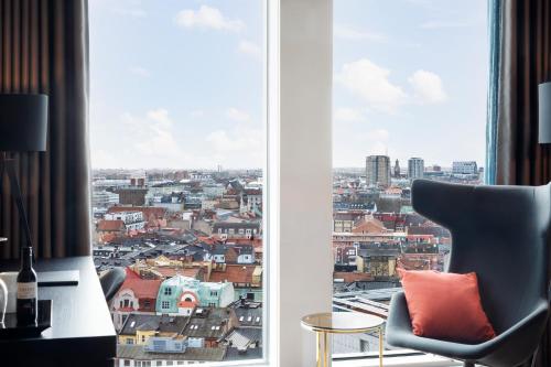a chair sitting in front of a window with a view at Clarion Hotel Malmö Live in Malmö