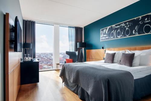 a hotel room with a bed and a large window at Clarion Hotel Malmö Live in Malmö