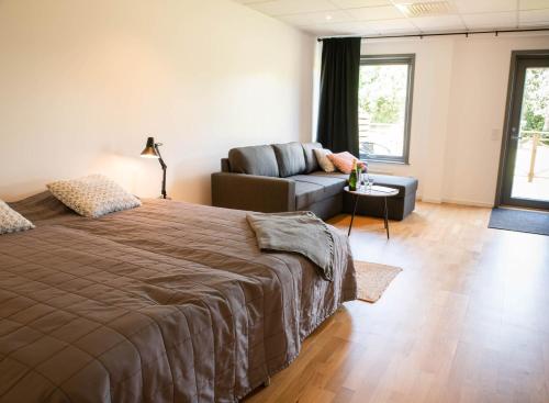 1 dormitorio con 1 cama y 1 sofá en Kungälv-Kode Golf Club Bed & Breakfast, en Kode