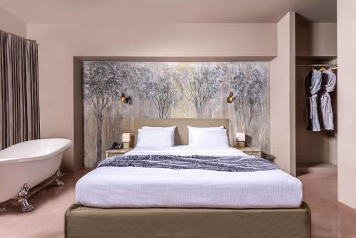 a bedroom with a large bed and a bath tub at Andronis Athens in Athens