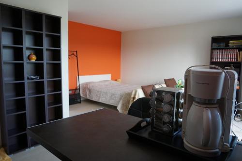 1 dormitorio con 1 cama y una cafetera sobre una mesa en Chez Brigitte, un séjour en Haute-Loire, en Saint-Germain-Laprade