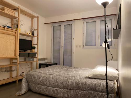 - une chambre avec un lit et une lampe dans l'établissement Votre pied a terre sur le port de La Rochelle, à La Rochelle