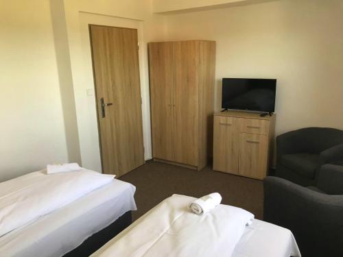 a hotel room with two beds and a television at Pension Berten Strašice in Strašice