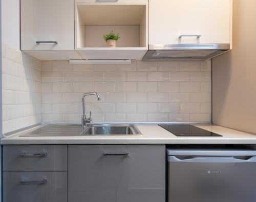 a kitchen with white cabinets and a sink at Denisa Studios in Sarti