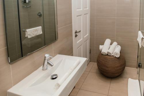 a white bathroom with a sink and a mirror at The View Boutique Hotel & Spa in Amanzimtoti
