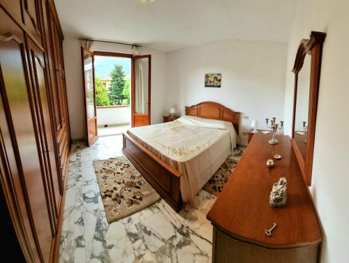 a bedroom with a bed and a wooden dresser at Casa Valentini in San Giuliano Terme