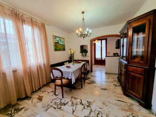 a dining room with a table and chairs and a chandelier at Casa Valentini in San Giuliano Terme