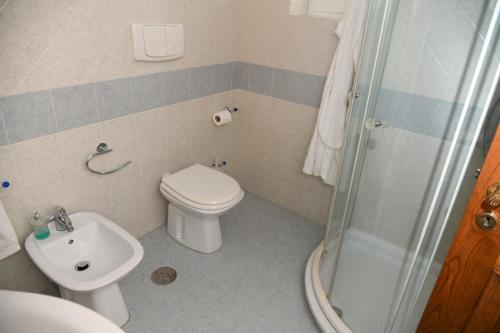 a bathroom with a toilet and a sink and a shower at Casa Lucy in Ercolano