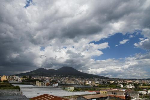 a city under a cloudy sky with a mountain at Casa Lucy in Ercolano