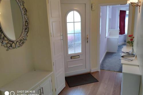 a bathroom with a white door and a mirror at Cozy Entire Bungalow House in Winchmore Hill
