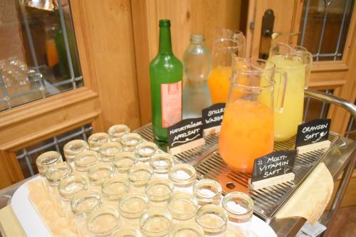 a table with a bunch of glasses and bottles of juice at Gartenhotel Kloepferkeller in Eibiswald